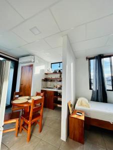 a bedroom with a table and a bed and a table and chairs at Family-friendly with balcony and terrace in Puerto Ayora
