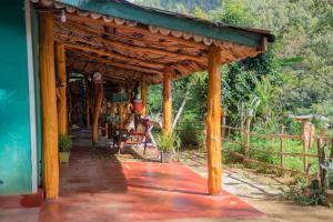 a porch of a house with a wooden roof at Blooming Rose Homestay in Ohiya