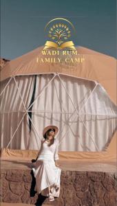 une femme portant un chapeau debout devant une tente dans l'établissement RUM FAMiLY BUBBLES &BEDOUIN CAMP, à Wadi Rum
