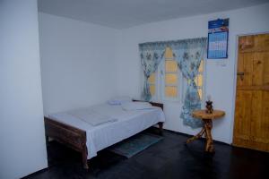 a bedroom with a bed and a window and a table at Blooming Rose Homestay in Ohiya