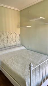a bedroom with a bed with a white bedspread at El piso del pueblo in Mansilla de las Mulas