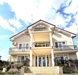 a white building with a balcony on top of it at Pensiunea Margareta in Baile Felix