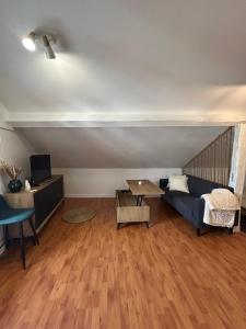 a living room with a blue couch and a table at Appartement cosy à 20 min de Disney in Gretz-Armainvilliers