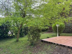 una passerella di legno in un parco con un albero di Villa Nature à TOULOUSE a Tolosa Altre 2 foto
