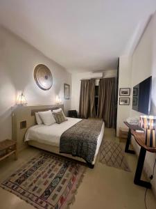 ein Schlafzimmer mit einem Bett, einem Tisch und einem Schreibtisch in der Unterkunft "LE 21", EXCLUSIVE LUXURY DUPLEX 400m FROM JEMAA EL FNA PLACE -HAMMAM-JACUZZI-KOUTOUBIA VIEW-ROOF TERRACE -SPEED WIFI in Marrakesch + 68 Fotos