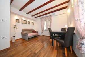 een woonkamer met een tafel en een bank bij Apartment Aldora in Zadar