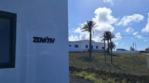 two palm trees in front of a white building at Palacio Eco in Tinajo