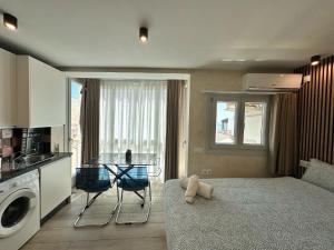 salon z łóżkiem oraz kuchnia z oknem w obiekcie PLAYA CARIHUELA Apartamentos El CARMEN w mieście Torremolinos