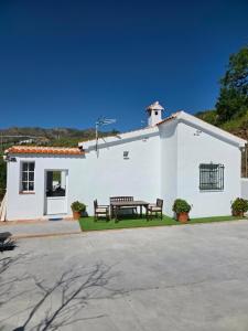 un edificio blanco con dos bancos y una mesa en CASA AGUILAR, en Cómpeta 28 fotos más