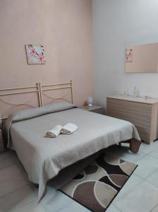 a bedroom with a bed with two shoes on it at Casa Natura in Avola