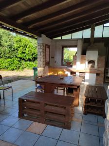 a patio with a wooden table and a fireplace at Casa Natura in Avola