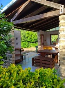 a patio with a wooden table and a bench at Casa Natura in Avola