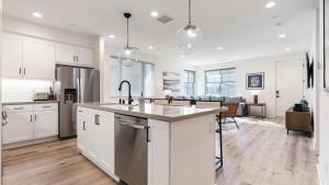 Una cocina con gabinetes blancos y una isla de cocina. en PGA208 Brand New PGA West 2 Bed 2 Bath w Loft, en La Quinta