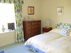 a bedroom with a bed and a dresser and a window at Westcourt Farm in Shalbourne