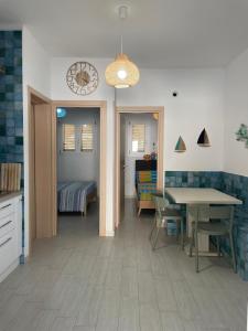 cocina y comedor con mesa y reloj en Casa Vacanza Blu, en Campomarino