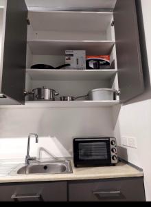 Una encimera de cocina con fregadero y microondas. en Luxury Apartment No. 202 (Napa Ace), en Ayia Napa