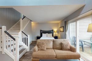 a bedroom with a bed and a staircase and a couch at Condo 310 at North Creek Resort in Blue Mountains +24 photos