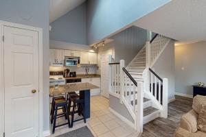 a kitchen with a staircase leading up to a loft at Condo 310 at North Creek Resort in Blue Mountains