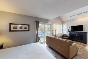 a bedroom with a bed and a living room with a fireplace at Condo 310 at North Creek Resort in Blue Mountains