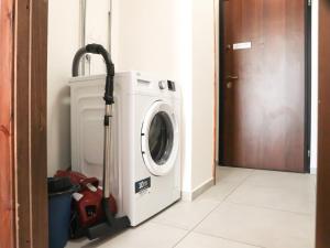 a washing machine with a vacuum next to a door at -Casa Trevisone- in Salerno