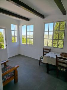 a room with a table and chairs and windows at CASA AGUILAR in Cómpeta +28 photos