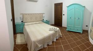a bedroom with a bed and a blue cabinet at Domo Rosada in Ottava Sassari