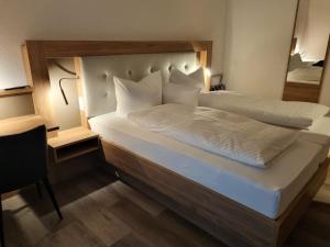 诺德代希Hotel Julia am Deich的卧室里有一张大床，床单和枕头都是白色的