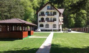 uma casa com um gazebo em frente a um quintal em Vila A&N em Brasov