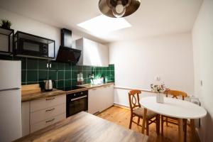a kitchen with a white table and a white refrigerator at Apartament OldTown Toruń in Toruń
