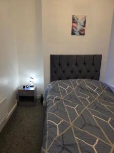 ミドルズブラにあるModern 3 Bed Home Central Location free WiFi Netflix and street parkingのベッドルーム1室(黒いヘッドボードとテーブル付きのベッド1台付)