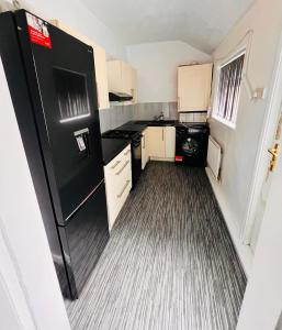 ミドルズブラにあるModern 3 Bed Home Central Location free WiFi Netflix and street parkingの小さな部屋に黒い冷蔵庫が置かれたキッチン