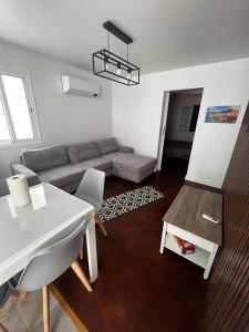 una sala de estar con un sofá y una mesa en Great Stay T3 Funchal Central Duplex Retreat, en Funchal