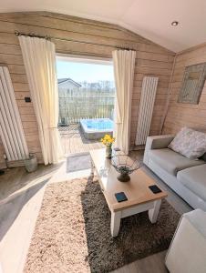 a living room with a couch and a coffee table at 1 or 2 bedroom Hot tub Lodges in North Walsham