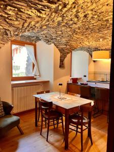 a dining room with a wooden table and a stone ceiling at Maison Arcade in La Salle