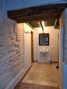 a hallway in a house with a stone wall at Hospedería Monasterio de San Leandro in Seville