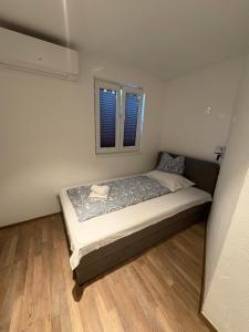 een bed in een kleine kamer met een raam bij The House in Medulin