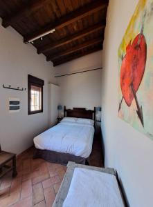 a bedroom with a bed and a painting on the wall at Hospedería Monasterio de San Leandro in Seville