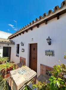 a patio with a table in front of a white house at Hospedería Monasterio de San Leandro in Seville +31 photos