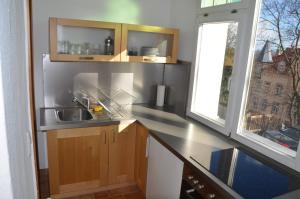 een kleine keuken met een wastafel en een raam bij Wölfele Apartment in Quedlinburg