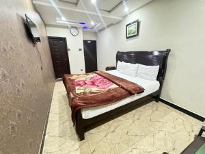a bedroom with a bed with a brown blanket on it at Star Residency Hotel in Islamabad
