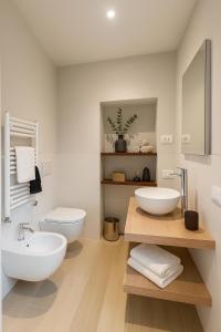 a bathroom with two sinks and a toilet at Villa Valesca in Stresa
