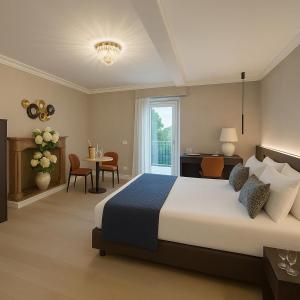 a bedroom with a large bed and a table and chairs at Villa Valesca in Stresa