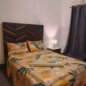 a bedroom with a bed with a bedspread with flowers at House Private Pool with Car in option in Pointe-Noire