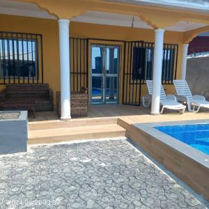 a house with a swimming pool and two chairs at House Private Pool with Car in option in Pointe-Noire