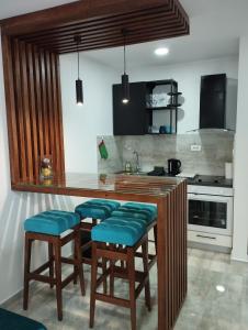 ヴェリコ・グラディシュテにあるApartman IDAのキッチン(カウンター、青いクッション付きスツール付)