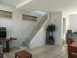 a living room with a staircase in a house at Grae’s Apartelle in Moalboal