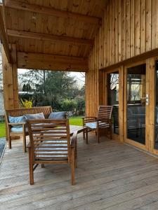 a wooden porch with chairs and a table on it at Chalet Chalus in Châlus