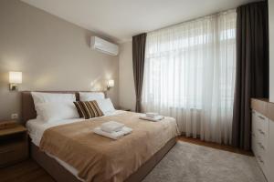 a bedroom with a large bed with towels on it at Brand New Luxury Apartments with Great Views in Sofia