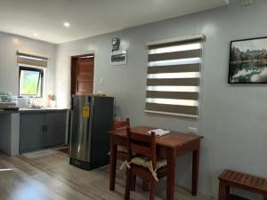 eine Küche mit einem Tisch und einem Kühlschrank in der Unterkunft Grae’s Apartelle in Moalboal + 31 Fotos