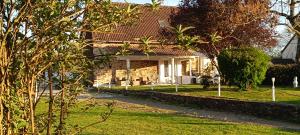 a brick house with a yard with grass and trees at Les Granges in Vigoulant